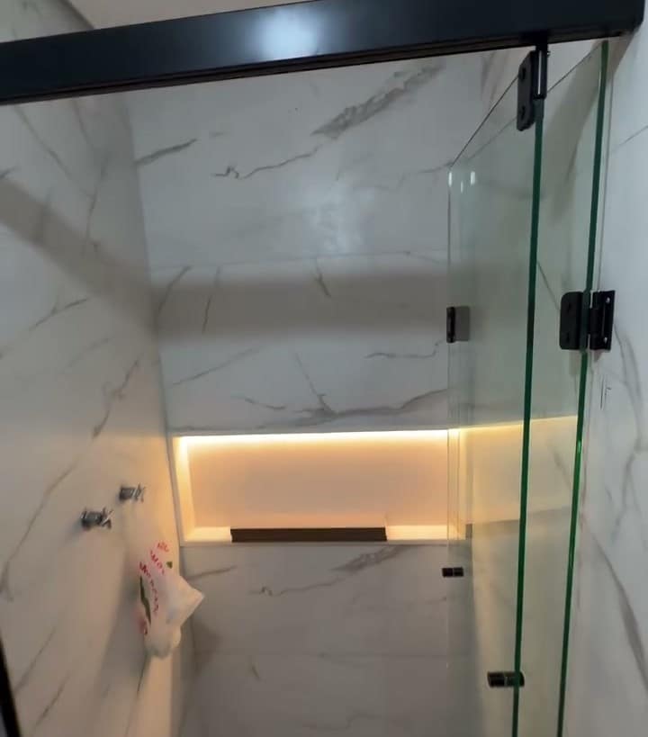 Box de vidro num banheiro com bancada de mármore