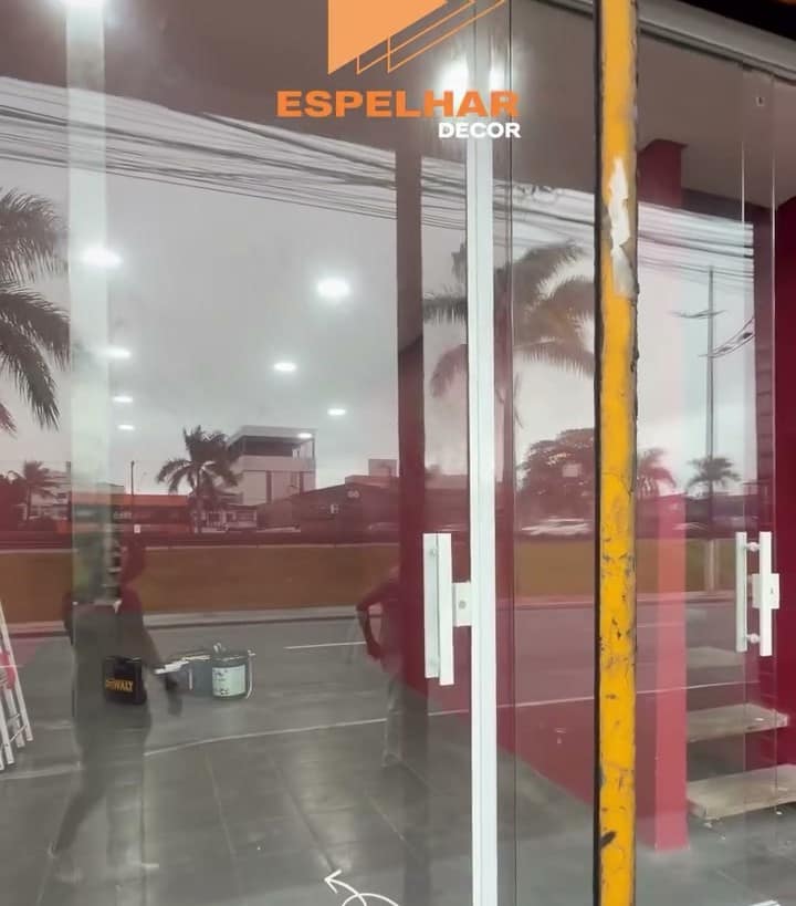 Fachada de loja fechada em vidro temperado, com a parede vermelha ao fundo