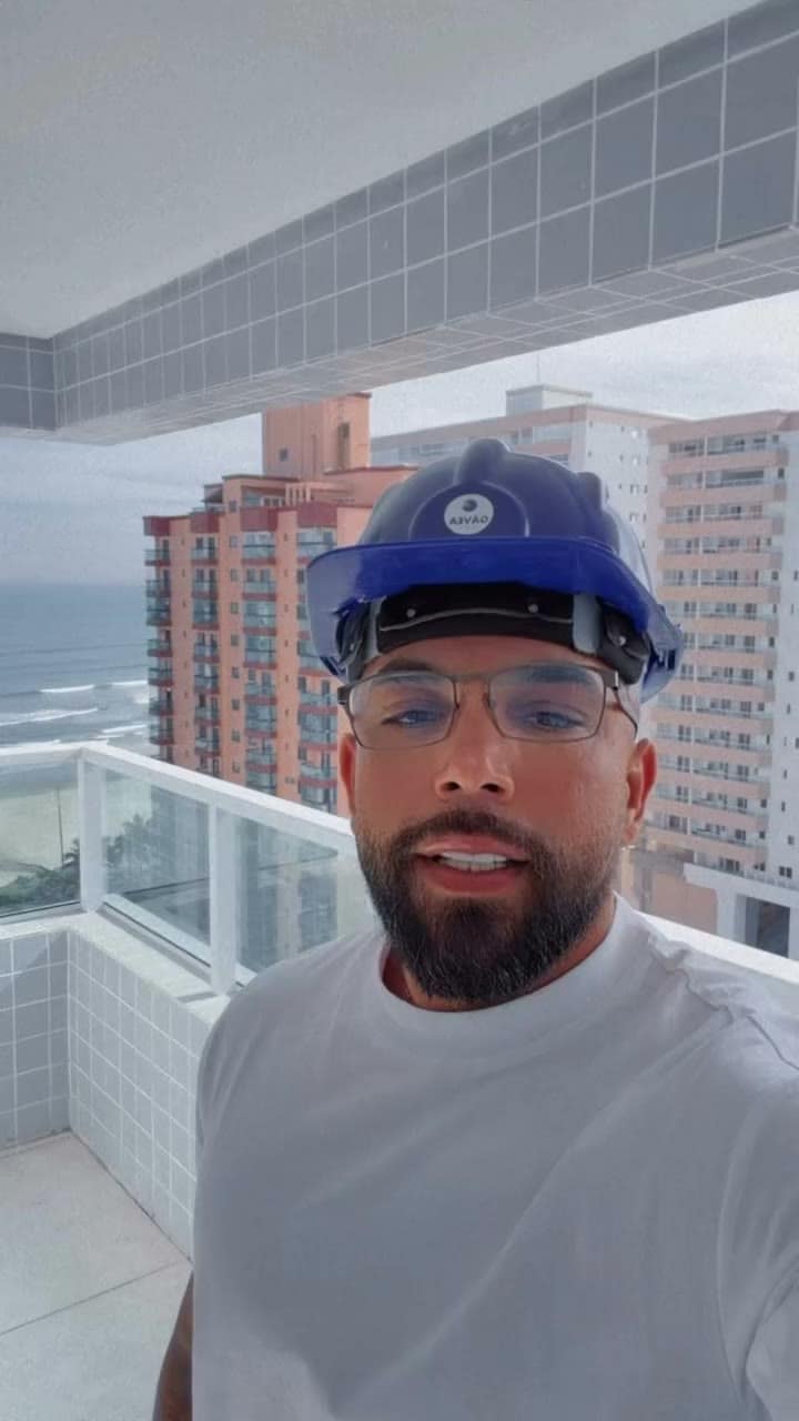 Instalador de capacete numa sacada alta com vista para o mar