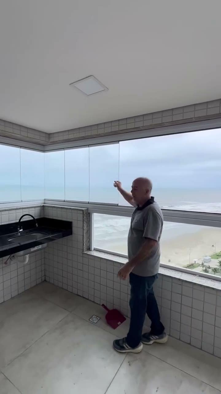 Sacada com vista para a praia e os painéis de vidro