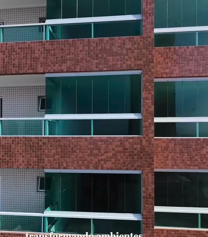Prédio de tijolos à vista com as sacadas envidraçadas