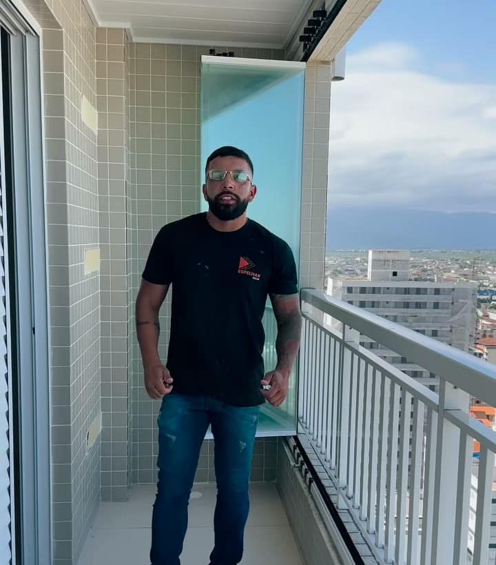 Sacada curva envidraçada com vista para os prédios