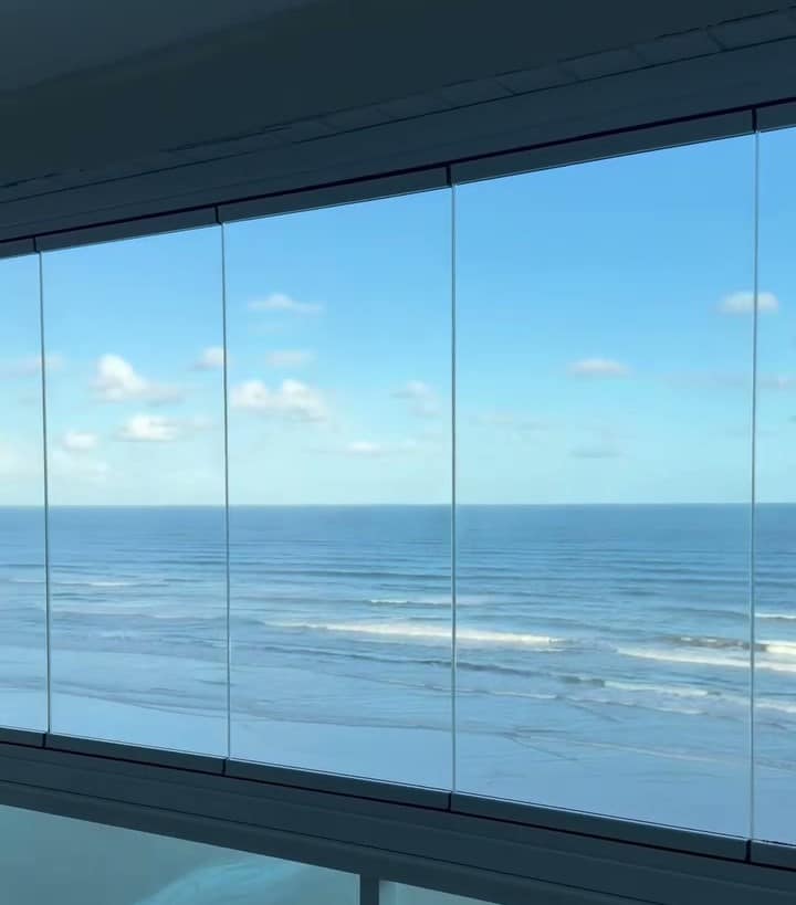 Painel de vidro de uma sacada de frente para o mar, visto de perto