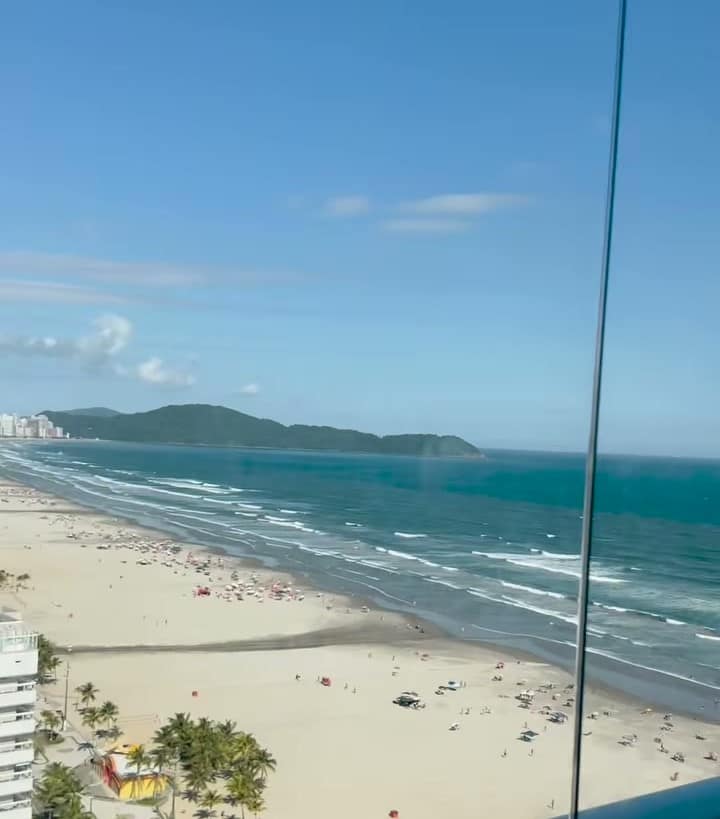A praia vista através do vidro de uma sacada