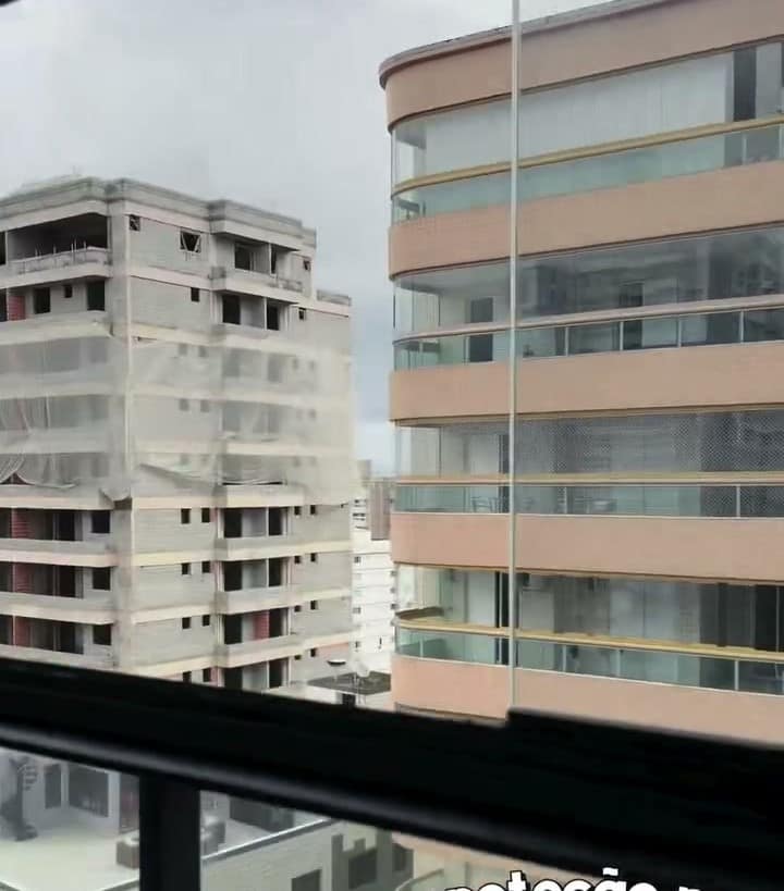 Envidraçamento com perfis pretos e vista para a cidade