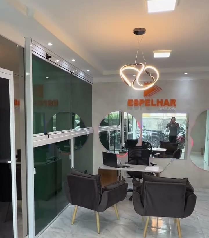 Espelhos redondos com LED e divisórias de vidro no showroom
