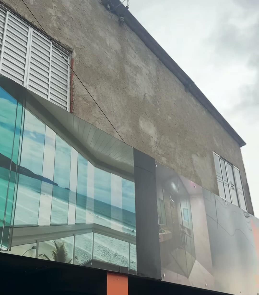 A fachada preta da loja da Espelhar Decor, com o logo laranja