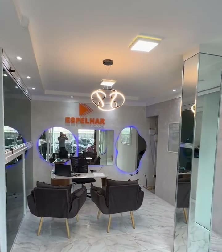 A recepção do showroom da Espelhar Decor, com poltronas e espelhos redondos